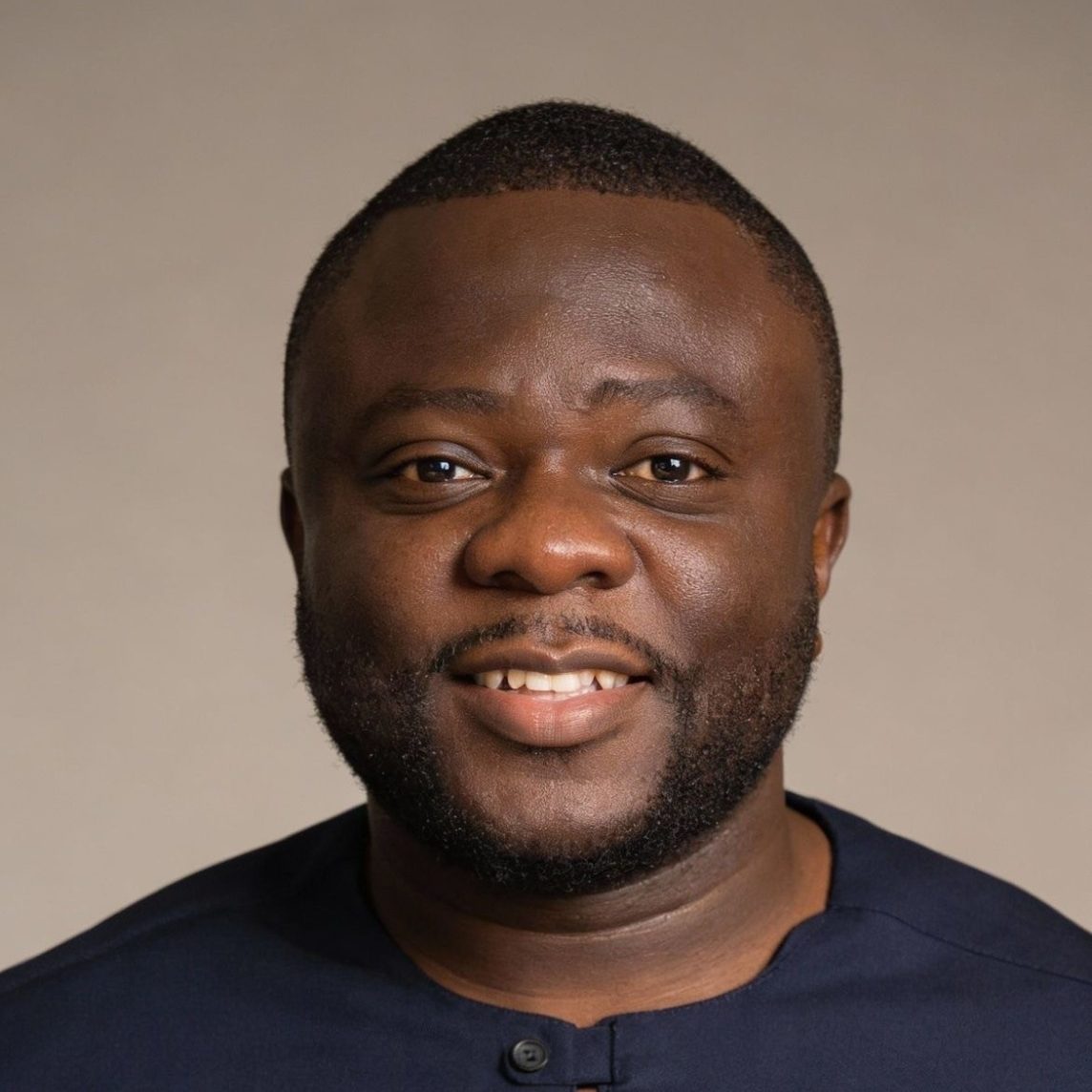 Man with a thoughtful expression, resting his chin on his hand, wearing a red sweater.