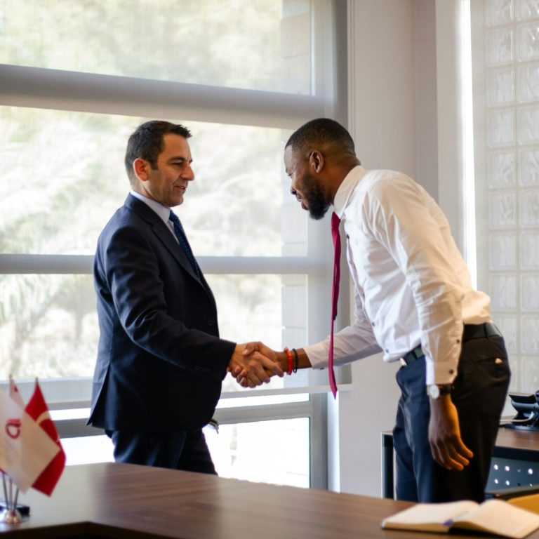 Group of five people in formal attire engaging in conversation with drinks.