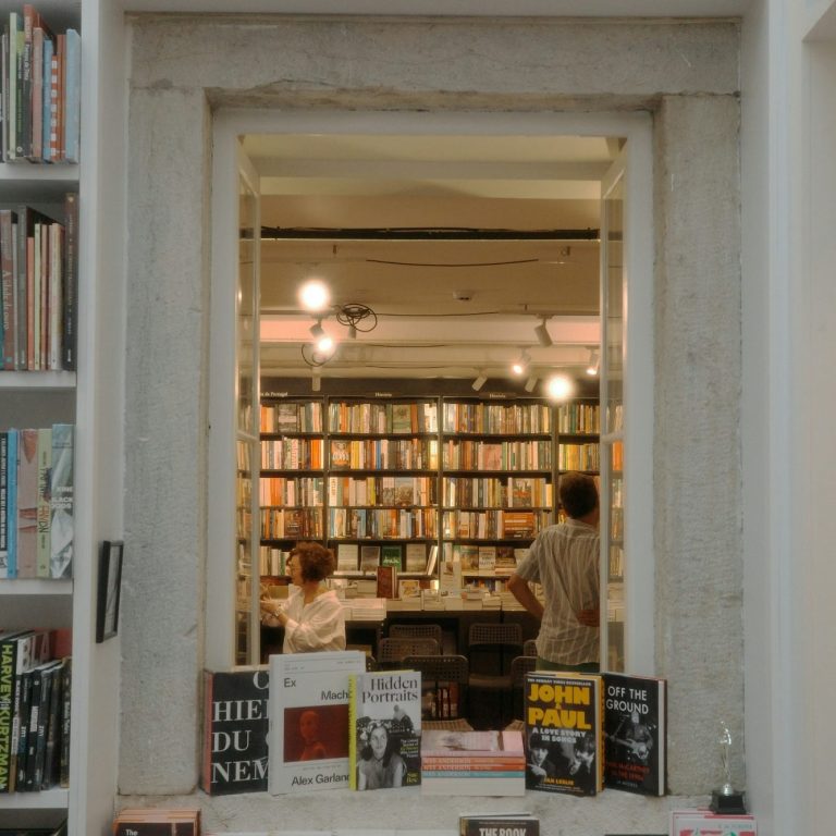 A man singing passionately into a microphone while wearing sunglasses and a vibrant hat.